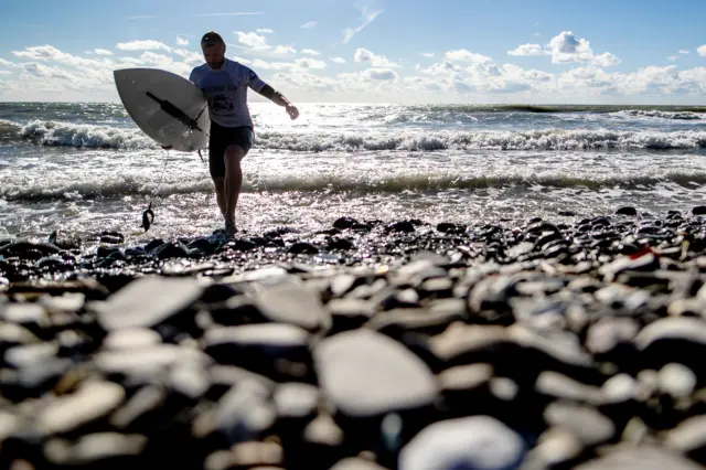 A surfer with a shortboard at the 2018 Russian Surfing Championships at the Khosta Rika surfing spot on the Black Sea coast