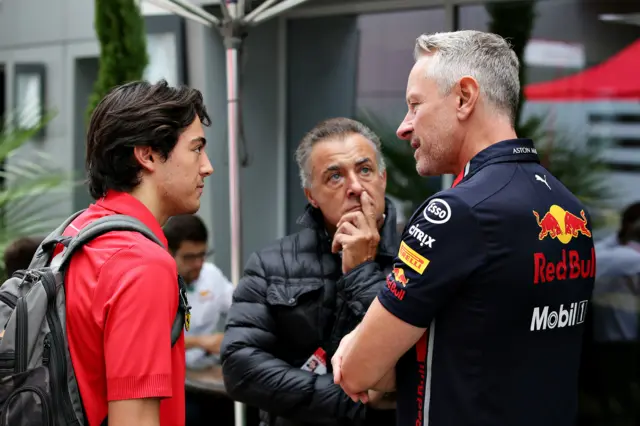 Red Bull team manager Jonathan Wheatley chats with former F1 driver Jean Alesi and his son, F2 driver Giuliano Alesi, in the paddock before final practice