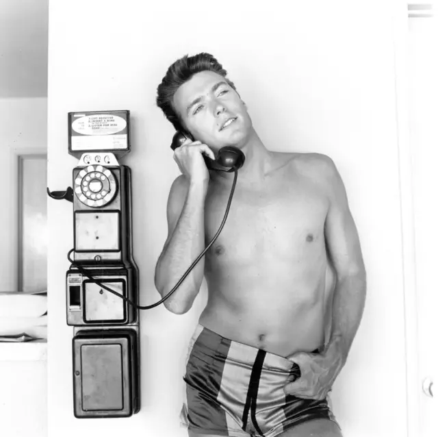 Actor Clint Eastwood talks on a pay phone outside his home on June 1, 1956 in Los Angeles, California