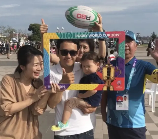 A family poses with a rugby ball