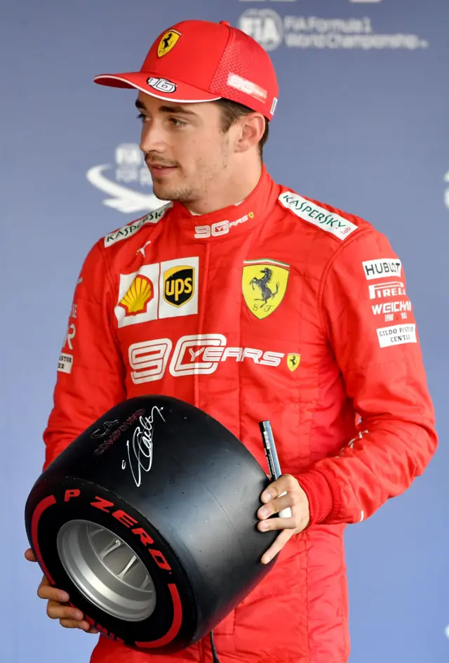 Charles Leclerc with a signed miniature tyre