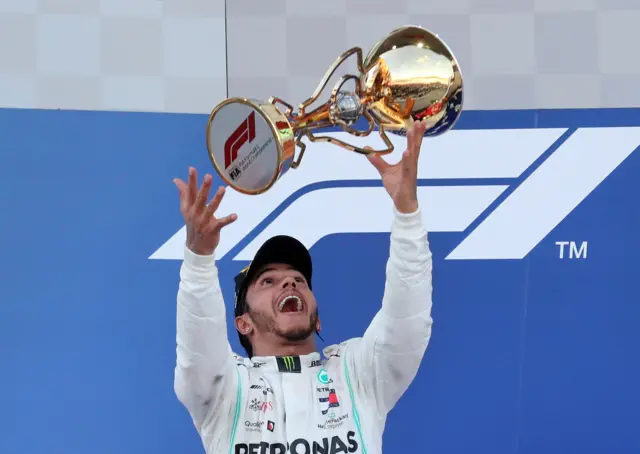 Lewis Hamilton celebrates with trophy