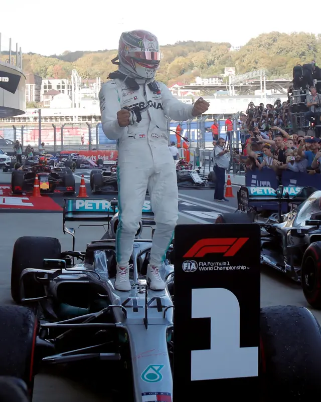 Lewis Hamilton in front of the number one board