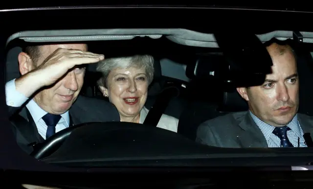 Theresa May sits in a car