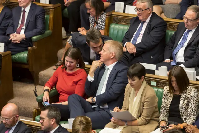 Lib Dem MP Tom Brake speaks to his new colleague Phillip Lee, who defected from the Conservatives this afternoon, after he crossed the floor and sat next to his new party's leader, Jo Swinson