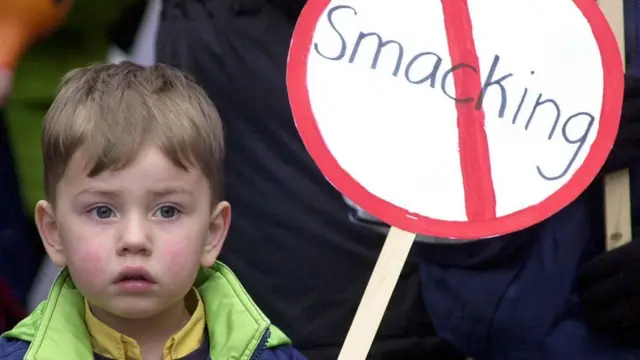 Child with sign saying no to smacking