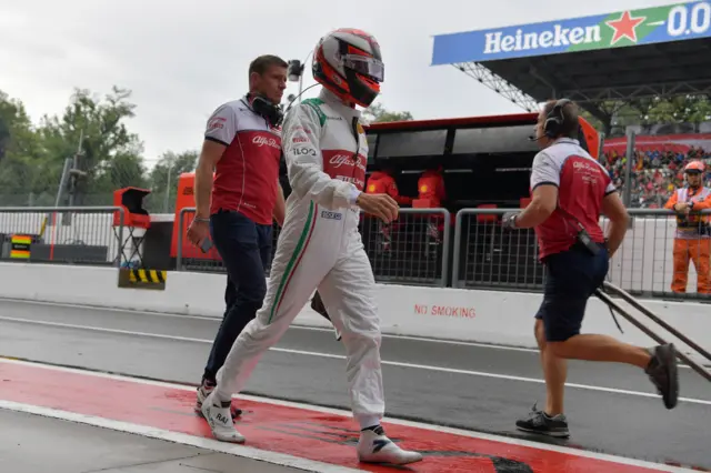 Kimi Raikkonen walks down the pit after crashing in first practice