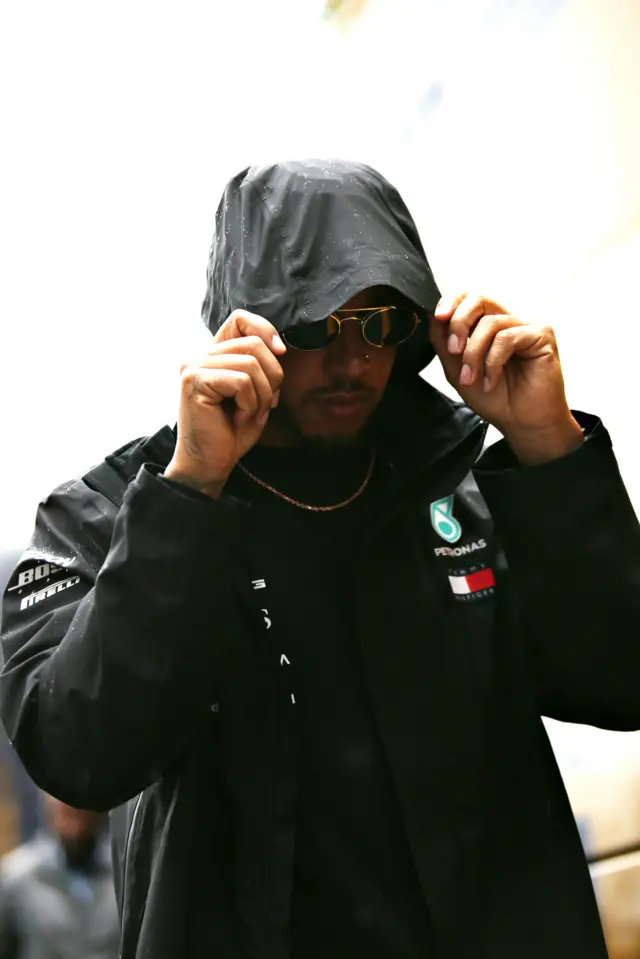 Lewis Hamilton with raincoat hood pulled up