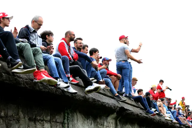 Spectators work hard to get the best vantage point of the action at Monza