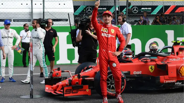 Charles Leclerc gives a thumbs up with Lewis Hamilton and Valterri Bottas watching on