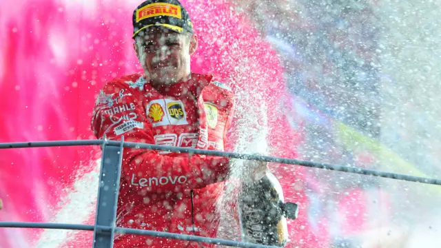 Charles Leclerc sprays champagne on the podium