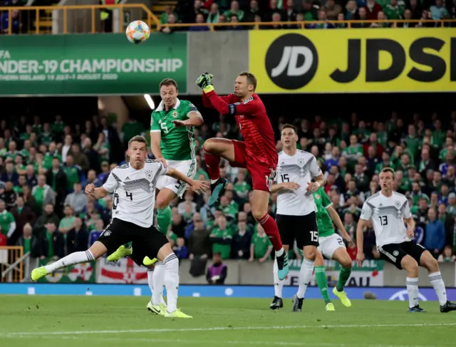 Manuel Neuer clears the danger from Jonny Evans