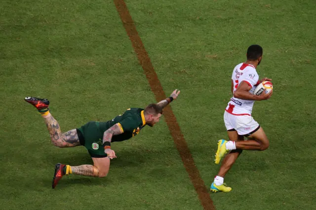 Kallum Watkins gallops away, before Josh Dugan brings him down with an ankle tap