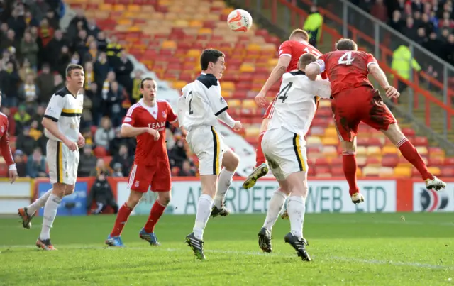 Adam Rooney (third right) heads the only goal of the game between Aberdeen and Dumabrton in 2014