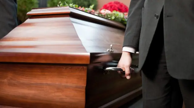 Coffin carried by coffin bearer.