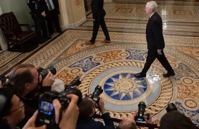 Top Republican Mitch McConnell walks past reporters as he arrives for the senate trial