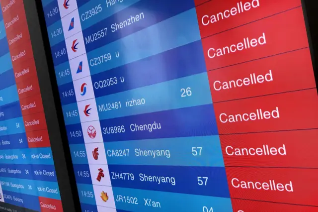 A flight board shows all flights cancelled