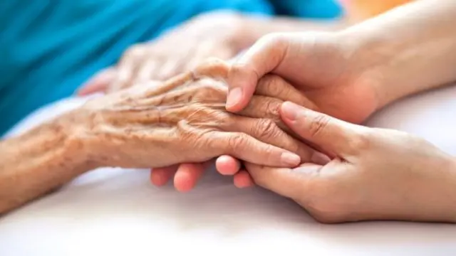 Older persons hand held by younger person