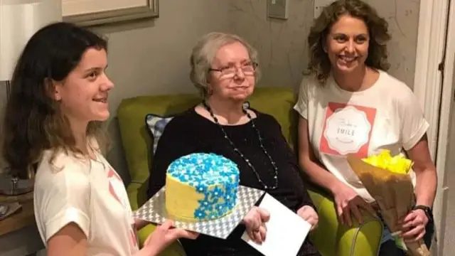 Liz and Grace Dougall delivering a cake to Carol