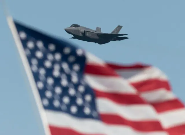 US Air Force Lockheed Martin F-35 flying above American flag