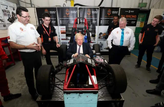 Boris Johnson sits in a racing car as he visits The Industry Centre at University of Sunderland