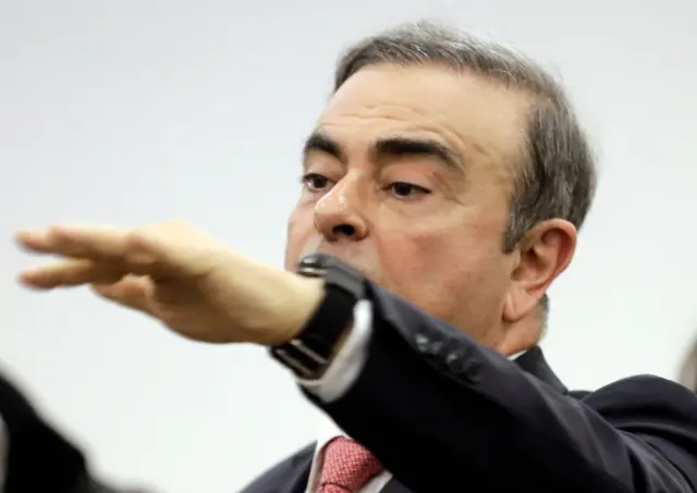 Carlos Ghosn pointing at news conferenece