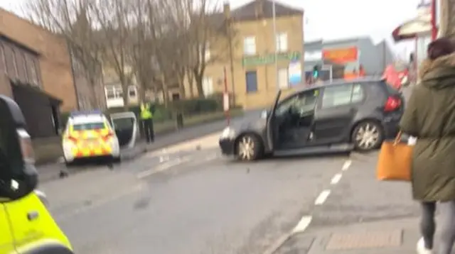 A damaged police car and a black car