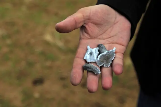 A man holds debris believed to have been from an Iranian missile, near Dohuk, Iraq