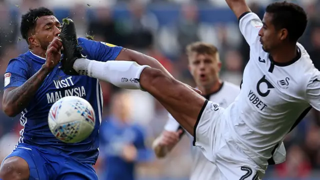 Swansea's Kyle Naughton (right) catches Cardiff winger Nathaniel Mendez-Laing with a flying boot