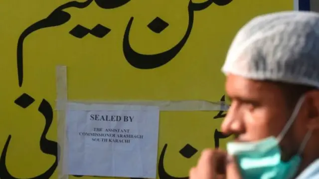 A man walks past a closed cafe in Pakistan