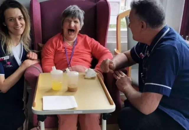 Kasia Cholewinska Kapuscinska, Nursing Assistant, Angela Morgan, resident, and Simon Walls, clinical lead at Saint Cecilia's nursing home