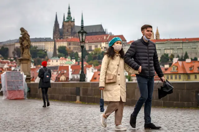 Tourists walk across medieval Charles Bridge on October 10, 2020 in Prague, Czech Republic