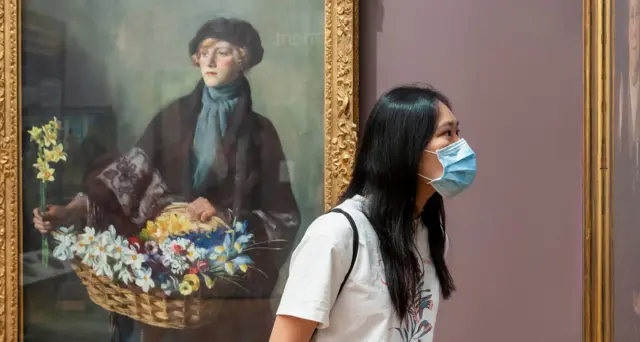A visitor admires a painting at Aberdeen Art Gallery