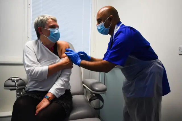 Kate Bingham demonstrates the vaccine process