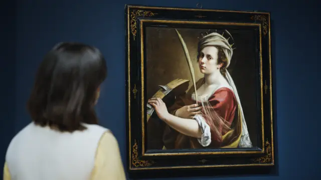 A visitor looks at a painting by Artemisia Gentileschi