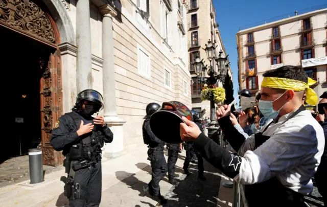 A member of the hospitality industry bangs a pot during a protest