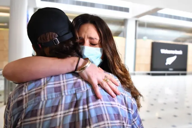 Taren Kowalski (R) is welcomed home by her boyfriend Jayden Guest (L) as she arrives from New Zealand, at Sydney International Airport on 16 October 2020