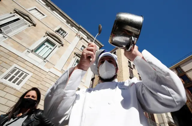 A protester bangs a pot