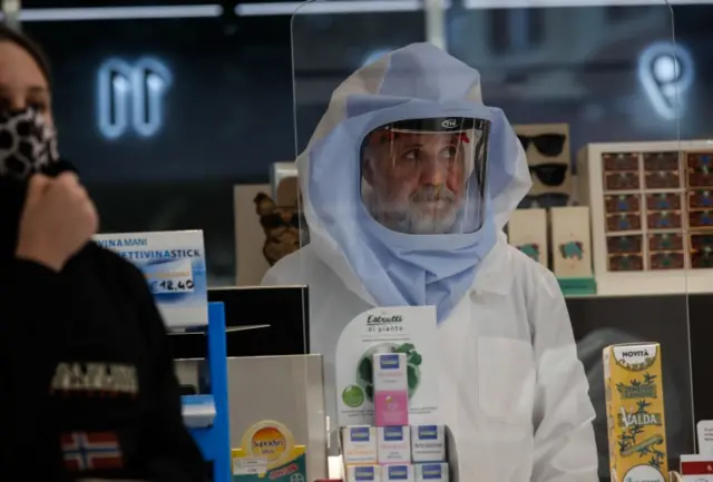 A pharmacist works while wearing a mask