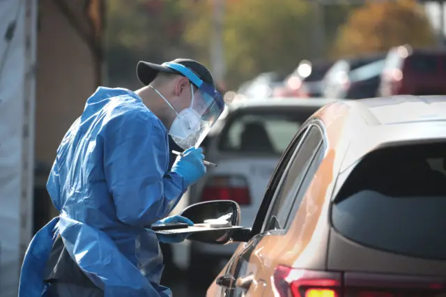 Members of the Wisconsin National Guard test residents for the coronavirus at a temporary test facility set up in the parking lot of the UMOS corporate headquarters on October 09, 2020 in Milwaukee, Wisconsin