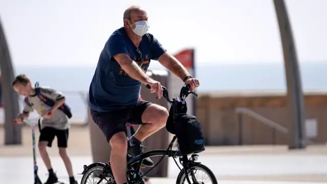 A man on a bike in a mask