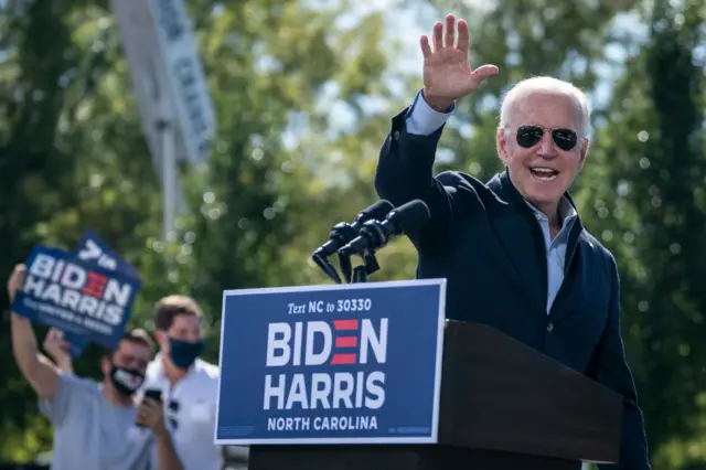 Democratic presidential nominee Joe Biden waves as he departs the stage during a drive-in campaign rally at Riverside High School on October 18, 2020 in Durham, North Carolina