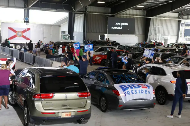 Supporters of Democratic U.S. Vice Presidential nominee Sen. Kamala Harris (D-CA) watch her give a campaign speech during an early voting mobilization event at the Central Florida Fairgrounds on October 19, 2020 in Orlando