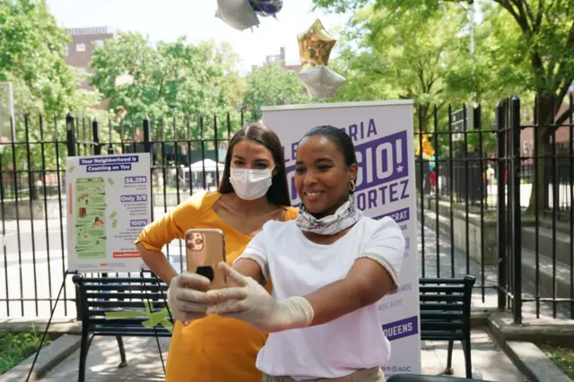 Democratic Rep. Alexandria Ocasio-Cortez, who is running for re-election, poses for a selfie with a volunteer as she launches an effort to increase voter registration and 2020 Census participation in New York's 14th Congressional District in the Borough of Queens on August 15, 2020 in New York