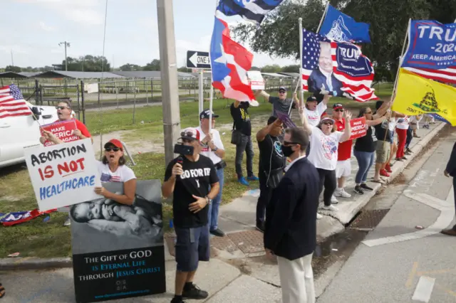 Supporters of President Donald Trump rally while Democratic U.S. Vice Presidential nominee Sen. Kamala Harris' (D-CA) motorcade enters an early voting mobilization event at the Central Florida Fairgrounds on October 19, 2020 in Orlando