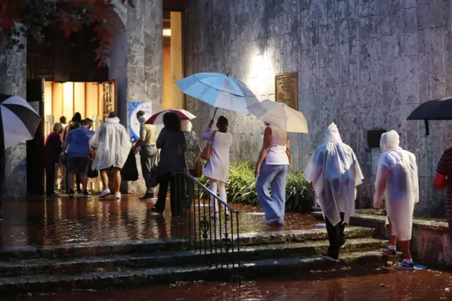 People queue in the rain in Florida on the first day of early voting