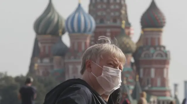 People wearing protective face masks walk on the Red Square in Moscow, Russia, 25 September 2020