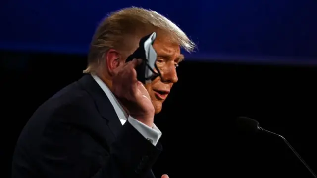 President Trump holds up a mask