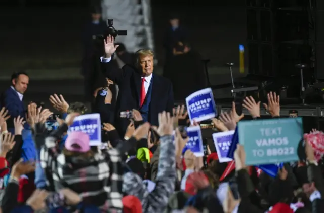 Trump greets a crowd after arriving at a rally in Minnesota, 30 September