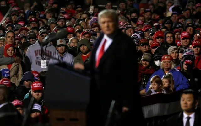 Supporters look on as Trump speaks at a campaign rally at Duluth International Airport in Minnesota